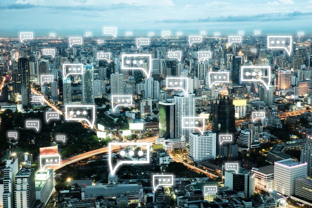 Communication chat icon above cityscape in the night light of the city.